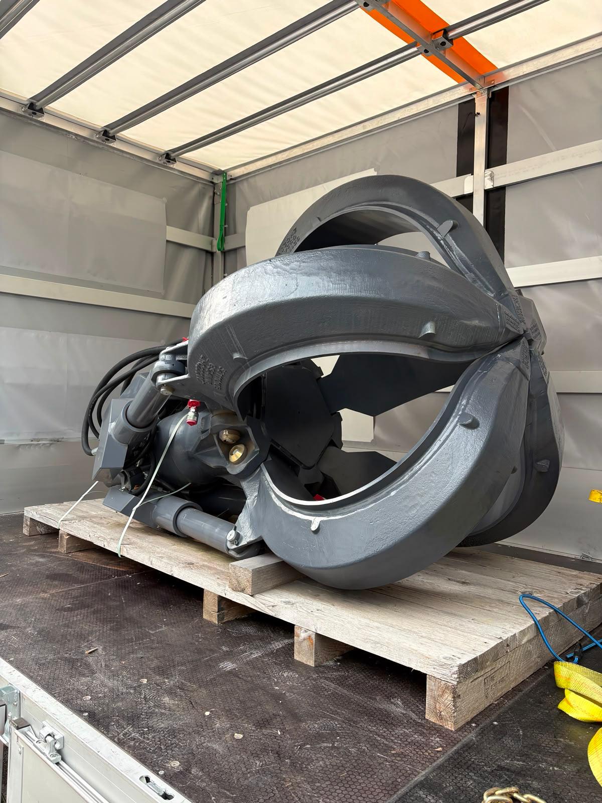 Fuchs orange peel grapple closed and secured inside the export truck, side view