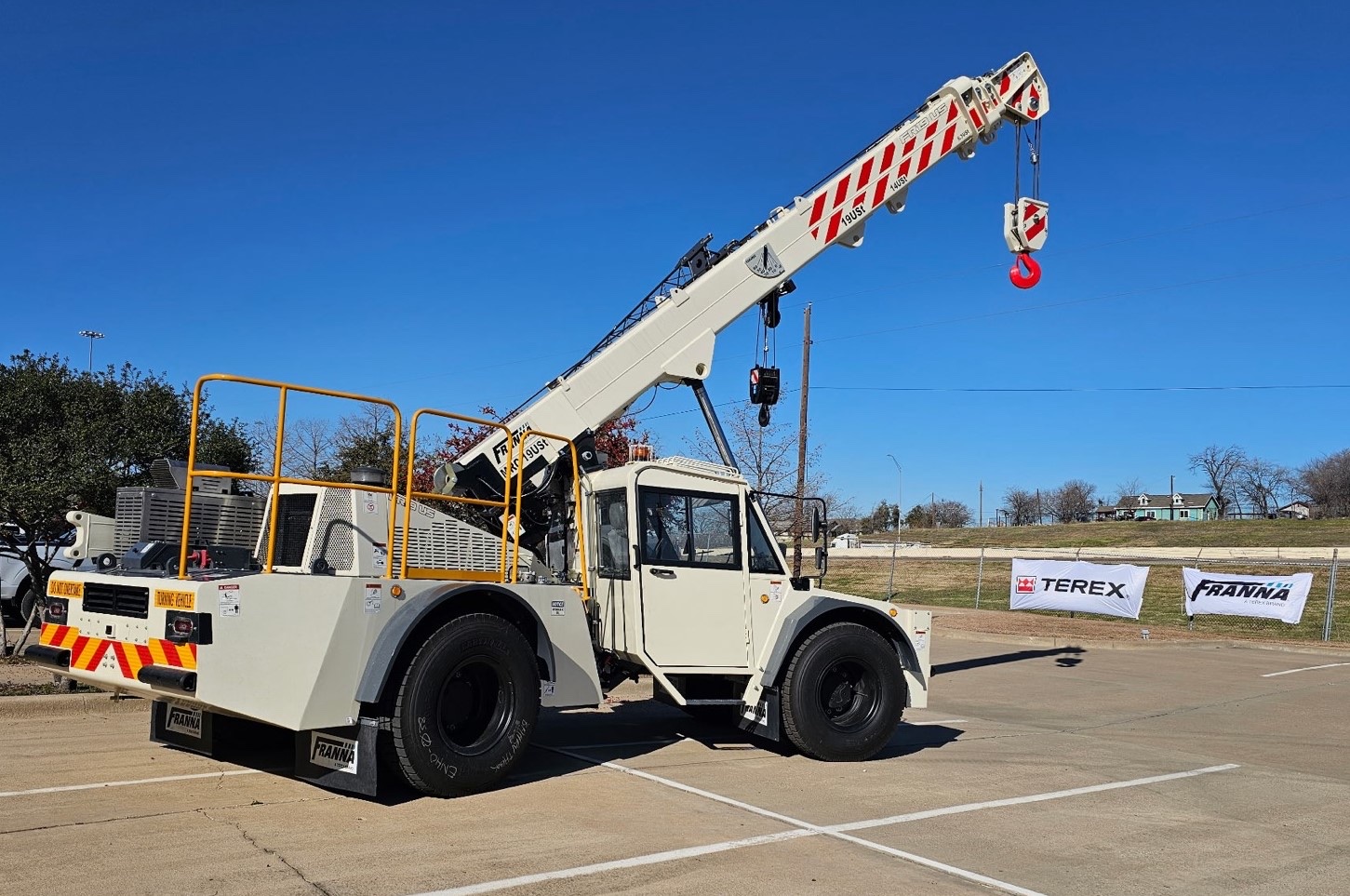 Franna AT24 US pick and carry crane with boom raised in front of Terex and Franna banners