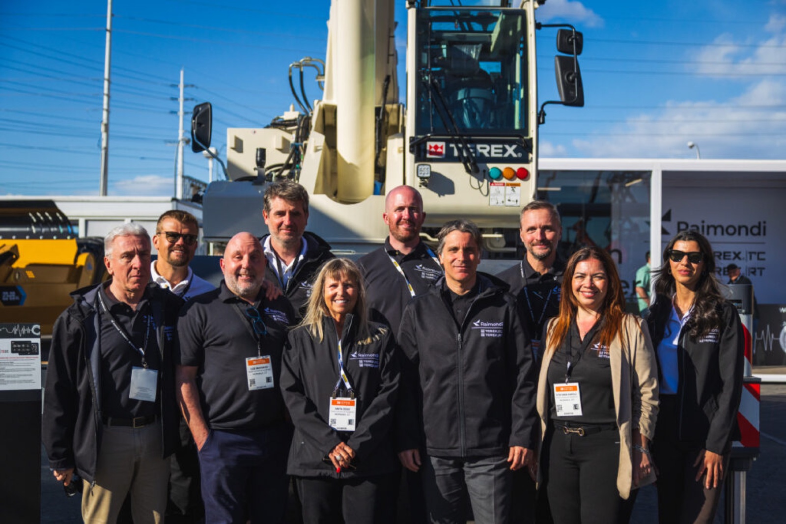 Raimondi and Terex Cranes team members standing in front of the Terex TRT 55US rough terrain crane at CONEXPO 2026